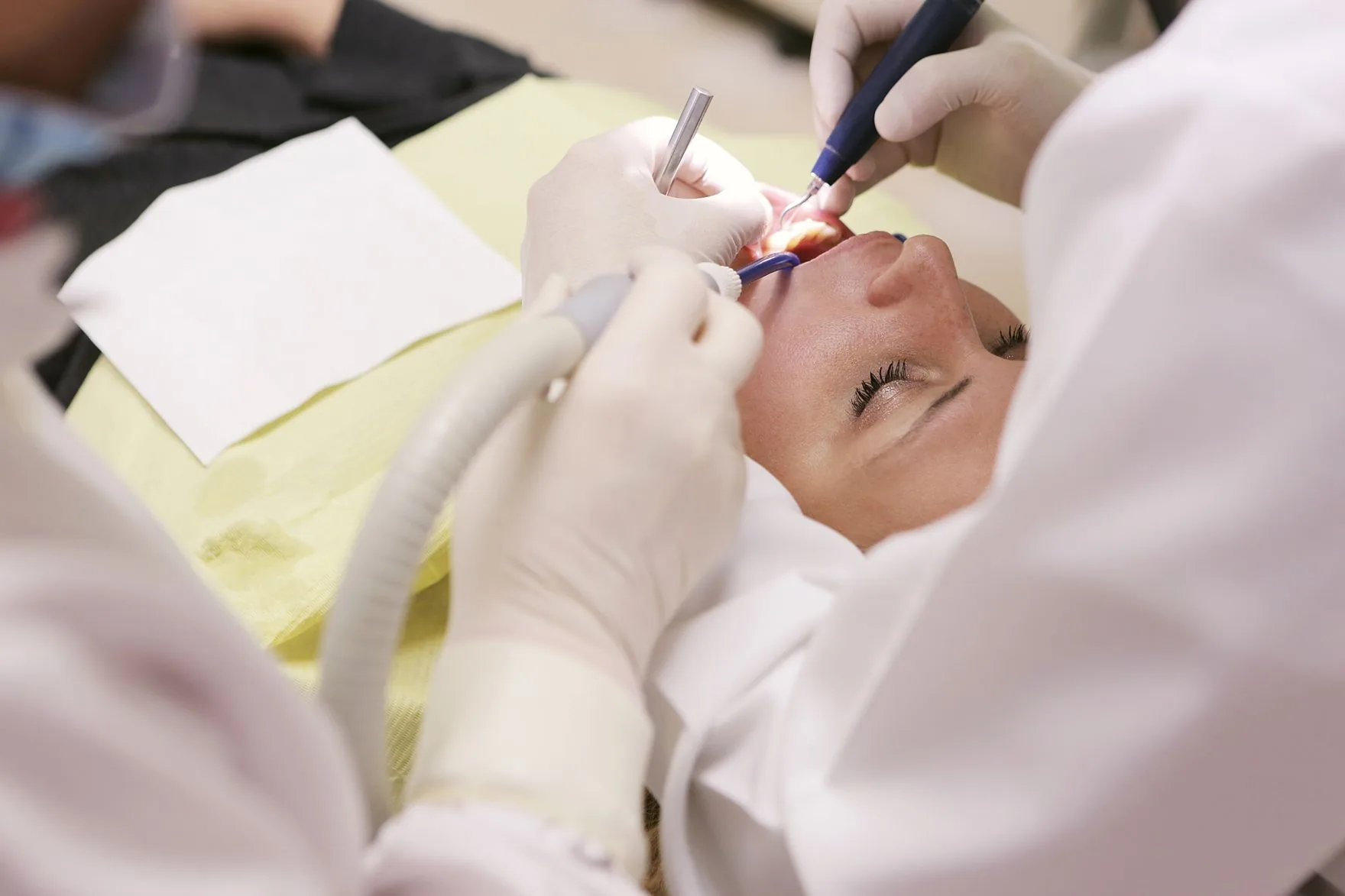Clinician carrying out a precise dental treatment under clinical lighting